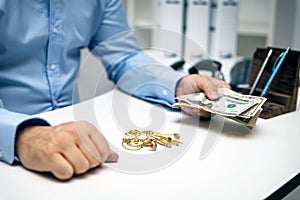 Man buying gold jewellry, pawn shop and us dollars photo