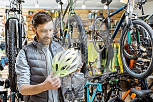 Man buying helmet in the bicycle shop