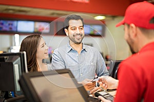 Man buying movie tickets for his girlfriend