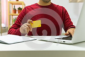 Man buying online with his credit card with his computer at home