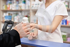 Man buying pill bottle in pharmacy.