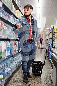 Man buying still water in grocery section