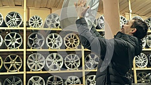 The man buys alloy wheels in his shop for his car.