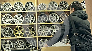 The man buys alloy wheels in his shop for his car.