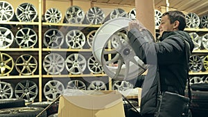 The man buys alloy wheels in his shop for his car.