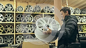 The man buys alloy wheels in his shop for his car.