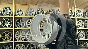 The man buys alloy wheels in his shop for his car.