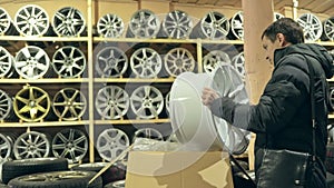 The man buys alloy wheels in his shop for his car.