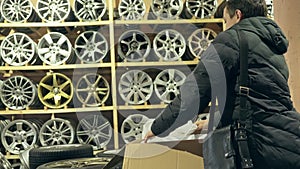 The man buys alloy wheels in his shop for his car.