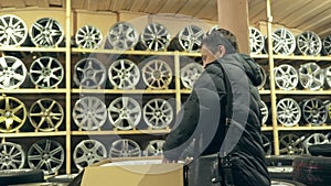 The man buys alloy wheels in his shop for his car.