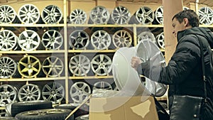 The man buys alloy wheels in his shop for his car.