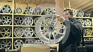 The man buys alloy wheels in his shop for his car.