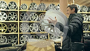 The man buys alloy wheels in his shop for his car.