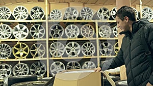 The man buys alloy wheels in his shop for his car.