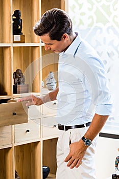 Man at cabinet in furniture store