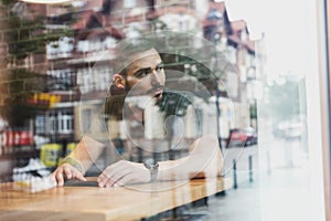 Man in a cafe reflecting in glass. City life