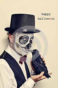 Man with calaveras makeup and crow, and text happy halloween