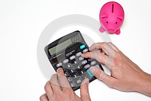 Man calculates money. Piggy bank and business documents on desk