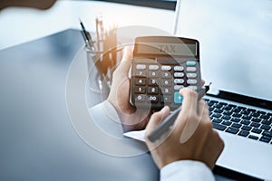 A man calculates taxes with a calculator.