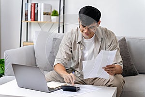 Man is calculating annual tax with calculator and filling form of Individual Income Tax Return. Season to pay Tax and Budget