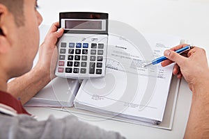 Man calculating financial expenses at home photo