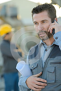 Man calling with cell phone outise factory