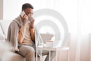 Man Calling Doctor Blowing Nose In Paper Tissue At Home