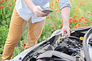 Man calling for help with mobile phone. Broken down car on the road