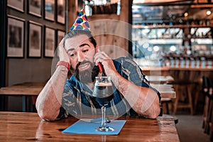 Man calling his friends waiting for them in pub on his birthday