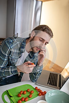 Man calling his mom for asking reccommendations about cooking