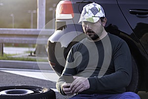 Man calling road assistance on the highway. Calling car service, assistance or  tow truck while having troubles with his car