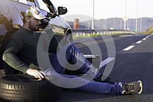 Man calling road assistance on the highway. Calling car service, assistance or  tow truck while having troubles with his car