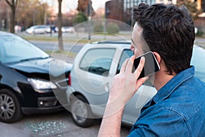 Man calling roadside emergency after car accident