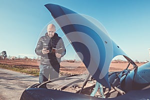 Man calling roadside service, assistance with his car broken down, car problem, transport concept photo