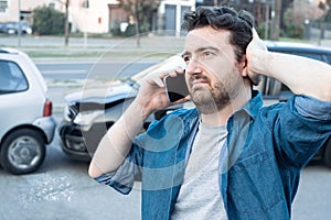 Man calling roadside service after car crash