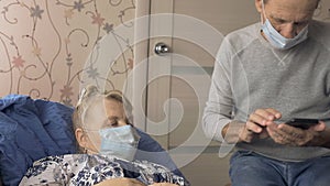 The man calls the doctor for a sick wife, an elderly couple in a medical mask