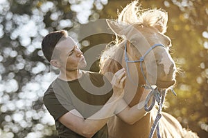 Man calming horse during obedience training