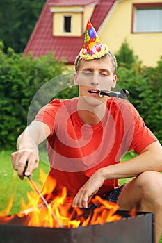 Man with calumet near brazier on picnic