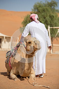 Man with camel in Wahiba Sands desert in Oman