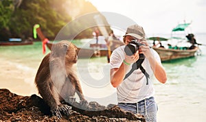 Man, camera and monkey with holiday, beach and tropical island with getaway trip, Bali and tourism. Person, photographer