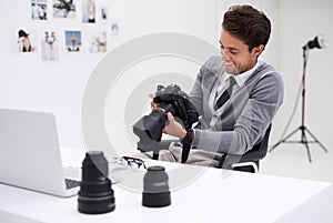 Man, camera and photography in office with happy smile, checking image batch and creative in workplace. Person, thinking
