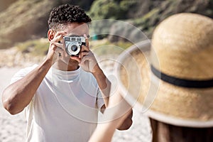 Man, camera and photography with woman at beach, couple on holiday for travel and memory together. Honeymoon, date or