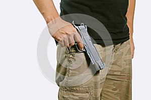 Man in a camouflage pants holding a gun isolated on white background