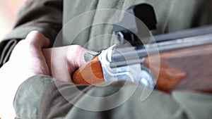 A man in camouflage prepares weapon for shooting.