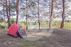 Man camping near the tent in the forest