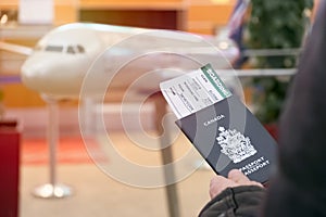 A man with a Canadian passport and boarding pass looks departure