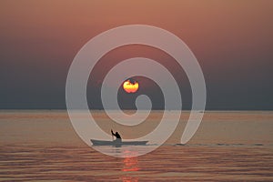 Man in a canoe at sunrise