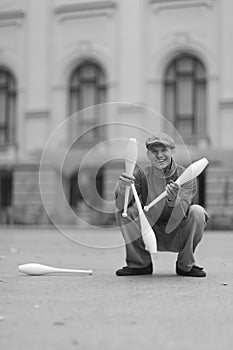 A man in a cap demonstrates maces in a street