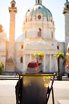 A man in a cap tourist is resting on a chair talking via video link