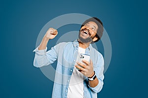 Man is captured in moment of elation, looking upwards and fist pumping air after a successful digital interaction photo